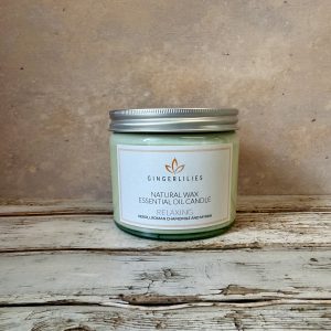Gingerlilies Relaxing essential oil candle in small glass jar with silver lid, labelled "Natural Wax Neroli Roman Chamomile & Ylang Ylang", featuring orange leaf logo on white label.