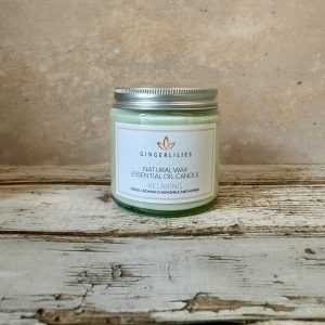 Gingerlilies Relaxing essential oil candle in small glass jar with silver lid, labelled "Natural Wax Neroli Roman Chamomile & Ylang Ylang", featuring orange leaf logo on white label.