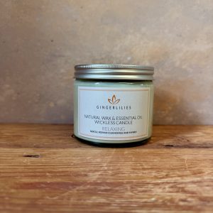 Gingerlilies Relaxing essential oil candle in small glass jar with silver lid, labelled "Natural Wax Neroli Roman Chamomile & Ylang Ylang", featuring orange leaf logo on white label.